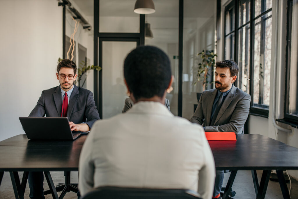 Two male recruiters having a job interview with a female applicant.