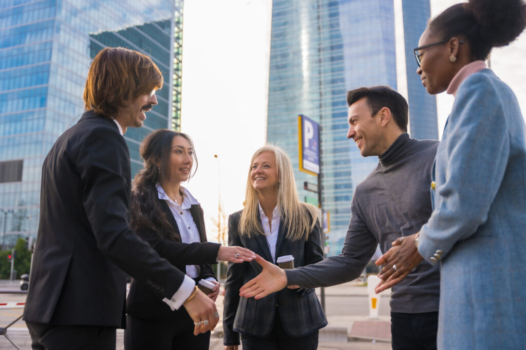 Sales professionals shaking hands with customers during a direct outreach.